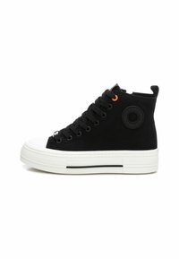 Zapatillas altas negras de lona con suela de goma. Entre sus características se incluyen la puntera blanca, cordones negros gruesos y un acento naranja en el ojal.