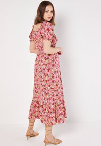 Maxikleid mit Blumenmuster in Rosa-, Rot- und Grüntönen, kurzen Puffärmeln, tailliertem Schnitt und weit auslaufendem Saum.