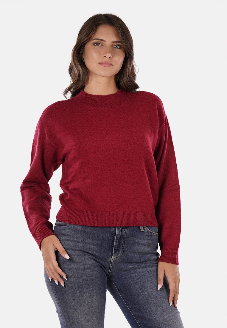 Maglione rosso lavorato a maglia con scollo rotondo, orlo a costine e maniche lunghe, abbinato a jeans in denim scuro. Tessuto morbido e vestibilità casual.
