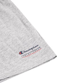Shorts atletici grigi in cotone con il logo "Champion" in blu navy e rosso. Design pulito e casual con una texture morbida.