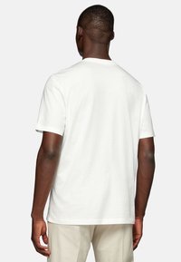 White cotton T-shirt with a crew neck and short sleeves. Smooth texture, casual fit, and a simple design with no visible patterns or accents.