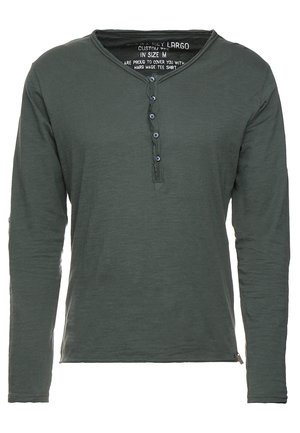 Langarm-Henley-Shirt in Dunkelgrün aus weichem Stoff mit einem Knopfverschluss am Hals, ausgestattet mit blauen Knöpfen und einem geraden Schnitt.