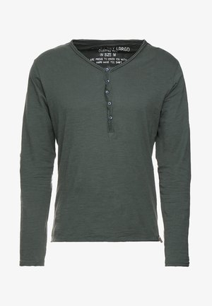 Langarm-Henley-Shirt in Dunkelgrün aus weichem Stoff mit einem Knopfverschluss am Hals, ausgestattet mit blauen Knöpfen und einem geraden Schnitt.