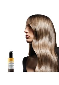 L'Oréal Professionnel Absolut Repair Molecular Oil, 150ml; slank gul flaske med sort pumpe, glat, skinnende, brunt hår der falder ned.