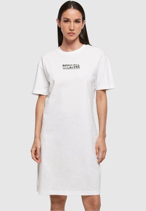 Weißes Baumwoll-T-Shirt-Kleid mit kurzen Ärmeln, das ein bedrucktes "RECKLESS"-Logo auf der Brust zeigt und eine gerade, knielange Silhouette hat.