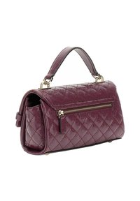 Sac à main matelassé violet foncé avec une poignée supérieure, une poche zippée à l'avant et des finitions en métal doré sur fond blanc.