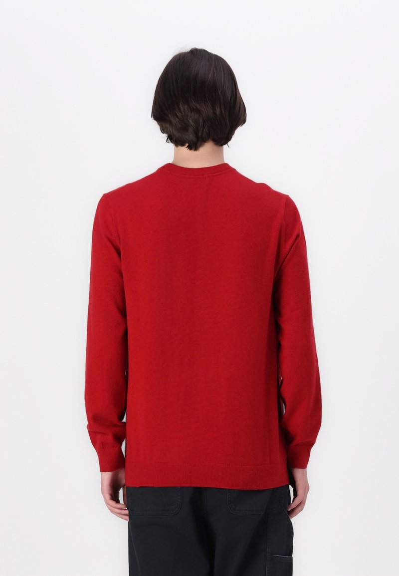 Suéter rojo de manga larga y cuello redondo, con una textura suave y puños y dobladillo de canalé, presentado desde la parte de atrás.