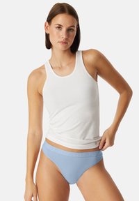 Ljusblå bomulls-bikiniunderbyxor med en slät yta och elastisk midja med präglad logotypdetalj, bärs med en vit linne.