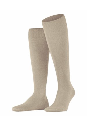 Calze beige alte fino al ginocchio realizzate in un tessuto morbido e liscio, con un risvolto a coste nella parte superiore e un design senza cuciture per la punta.
