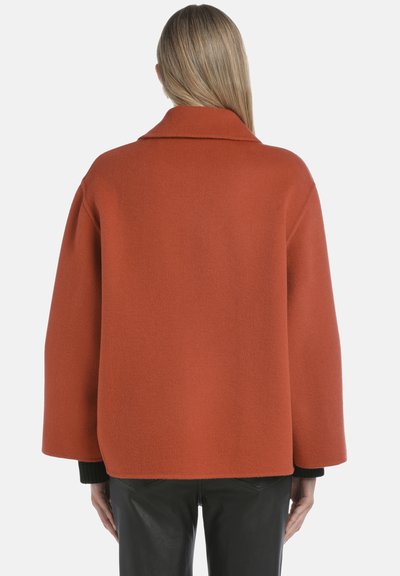 Palton portocalie din lână cu un guler lat, umeri lăsați și un design lejer. Are mâneci lungi și o finisare netedă, texturată.