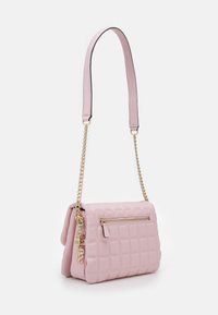 Różowa pikowana torebka na łańcuszku z zapięciem na zamek. Charakteryzuje się gładką teksturą i złotymi elementami, prezentując kompaktowy prostokątny kształt.