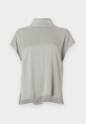 Blouse gris clair à manches courtes avec col montant et fentes sur les côtés, confectionnée dans un tissu doux et fluide avec un ourlet arrière légèrement plus long.