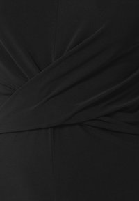 Vestido negro con un diseño anudado en la cintura, confeccionado en una tela suave y elástica, con una silueta estilizada y mínima textura.