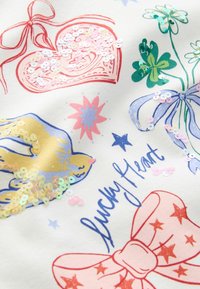 Biały materiał z kolorowymi ilustracjami serc, dłoni, gwiazd, kwiatów i kokard, ozdobiony cekinami w różnych pastelowych kolorach.