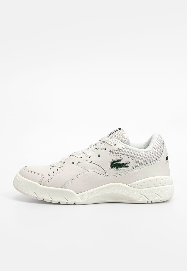 Baskets en cuir blanc avec des accents en mesh, bout rond, semelle en caoutchouc proéminente, design à lacets, et détail de logo vert sur le côté.