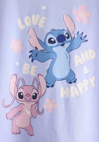 Blå og lyserøde tegneseriealiens med store ører omgivet af lyserøde blomster og ordene "Love be and happy" på en lyse lilla baggrund.