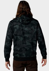 Sudadera con capucha de camuflaje negro que presenta una capucha con cordón, mangas largas y una cintura acanalada, mostrando una textura suave y un diseño entallado.
