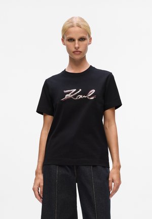 T-shirt in cotone nero con logo "Karl" in metallo rosso e argento ricamato sul davanti. Vestibilità classica con maniche corte.