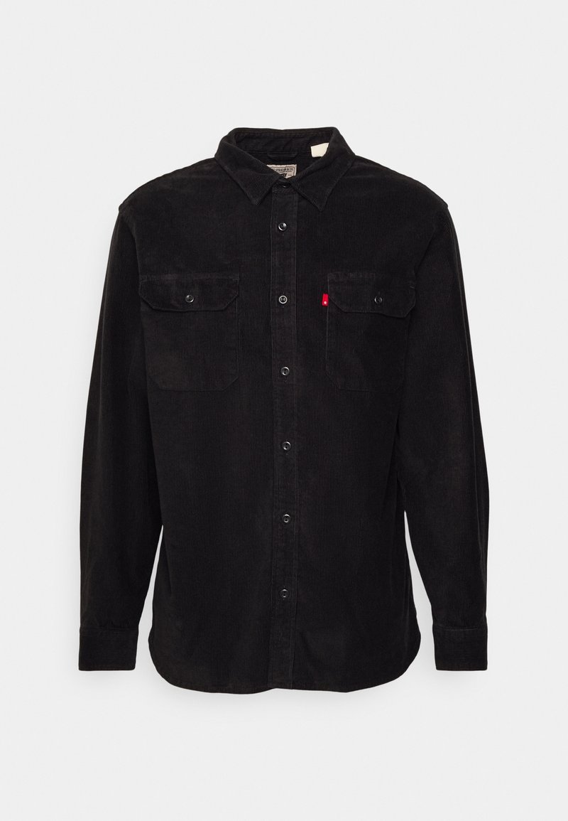 Chemise en velours côtelé noire à manches longues avec boutonnière à l'avant, deux poches poitrine à rabat avec boutons, et une petite étiquette rouge sur la poche gauche.