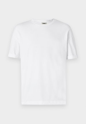 Valge puuvillane t-särk, ümmarguse kaelaauguga, lühikeste varrukatega ja rullitud varrukate äärtega; lihtne disain, pehme tekstuur ja sirge lõige.