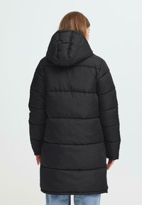 Sort pufferjakke med hætte, der har et quiltet design og vandrette sektioner. Ærmerne er lange, og jakken går til midt på låret.