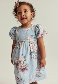 Vaaleansininen kukallinen mekko puffihihnoilla, jossa on vaaleanpunaisia ja sinisiä kukkia, pitsinen helma ja valkoinen lapuke brändin nimellä.