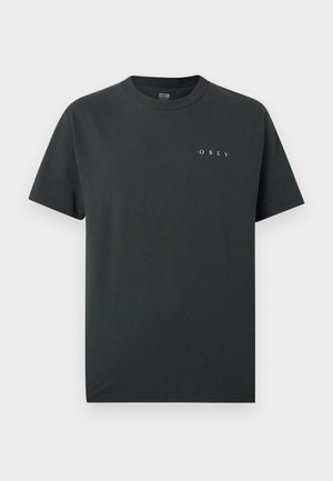 Μαύρο T-shirt με κοντά μανίκια και στρογγυλή λαιμόκοψη, με μικρό λευκό κείμενο «OBEY» τυπωμένο στο αριστερό στήθος.