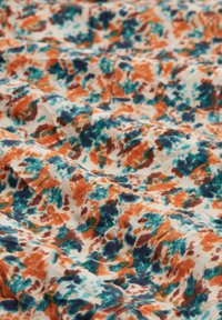 Leichter Stoff mit einer cremigen Basis, der ein lebhaftes abstraktes Muster in Orange, Teal und Dunkelbraun zeigt, mit weicher Textur und Drapierung.