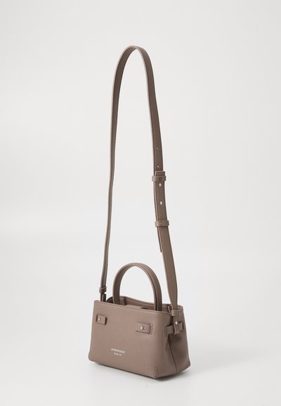 Pequeño bolso de cuero marrón con un diseño estructurado, asa superior y correa de hombro ajustable. Presenta sutiles acentos de metal.