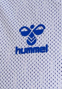 Tessuto a rete bianco con perforazioni blu presenta un design con il logo blu al centro, che legge "hummel". La consistenza è leggera e traspirante.