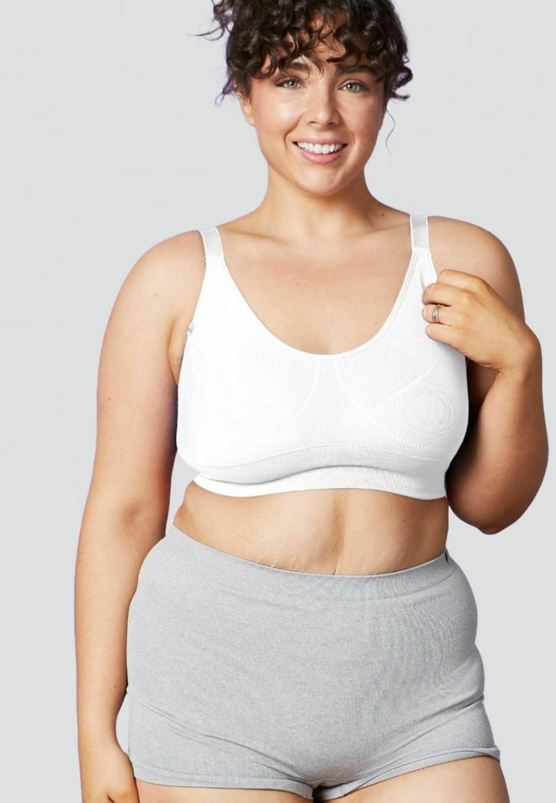 Top sportivo bianco a coste con spalline larghe e pantaloni corti grigi a vita alta in stretch. Tessuto morbido con una superficie liscia e dettagli di design minimi.