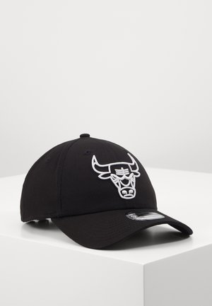 Gorra de béisbol negra hecha de tela, con un prominente logotipo de toro bordado en blanco en la parte frontal y una visera curva.