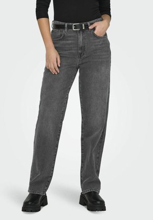 High-waisted black denim jeans in a relaxed fit, featuring belt loops, front pockets, and a sturdy texture. Paired with chunky black boots.