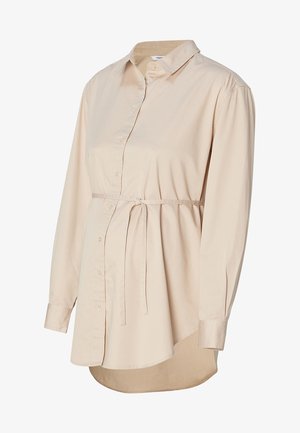 Chemise de maternité beige clair avec un devant à boutons, des manches longues, un col et une taille ajustable avec cordon. Présente un ourlet arrondi.