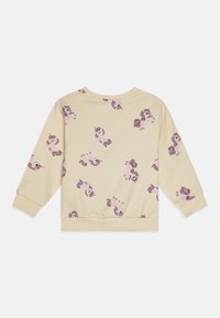 Sweatshirt beige clair avec un motif de licorne dans des tons violets. Il possède des manches longues, un col rond et un ourlet froncé à la taille.