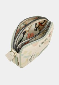 Bolsa multi-compartimentos con un exterior suave de color verde claro. Interior con un patrón que presenta diseños abstractos. Cremalleras metálicas y detalles de herrajes.