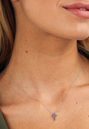 Silberne Halskette mit einer feinen Kette und einem Kreuzanhänger, der mit blauen Edelsteinen verziert ist. Das Kreuz ist vertikal ausgerichtet und verfügt über filigrane Details.