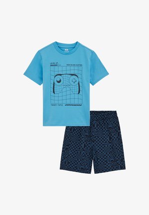 Maglietta azzurro chiaro con grafica di controller per videogiochi nero, abbinata a pantaloncini blu navy con motivo pixelato e vita elasticizzata.