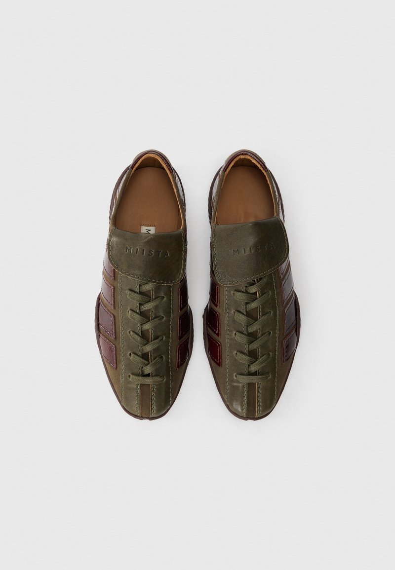 Green leather shoes with brown accents, lace-up design, and a padded tongue. Features ribbed texture and a logo embossed on the side.