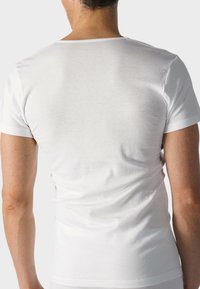 White cotton t-shirt with short sleeves, fitted design, and a rounded neckline. Smooth texture with no visible patterns or accents.