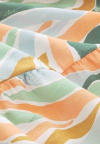 Mehrfarbiger Stoff mit gewellten Mustern in Grüntönen, Orange und Gold, der eine sanfte Textur und detaillierte Raffung aufweist.