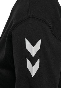 Zwarte sweatshirt met een gestructureerde stof en een ronde hals. Opvallende witte chevrongrafieken op de linkermouw.