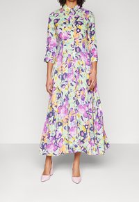 Kukallinen maksimekko pastellisävyissä, jossa on kaulus, kolmannes hihasta ja löysä siluetti. Yhdistettynä vaaleanpunaisiin korkokenkiin.