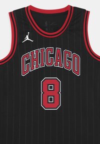 Svart baskettröja med röda vertikala ränder, "CHICAGO" i fet röda bokstäver, nummer "8," och vitt Jumpman-logotyp på vänster axel.