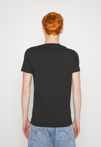 Calvin Klein Jeans SEASONAL MONOLOGO TEE - Apdrukāts T-krekls - black
