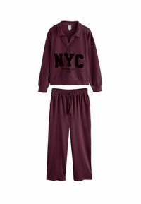 Completo loungewear color bordeaux, composto da un pullover a maniche lunghe con colletto e grafica "NYC", abbinato a pantaloni con elastico in vita.
