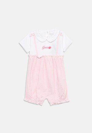 Combinaison blanche pour bébé avec jupe rayée rose, manches courtes, col Claudine, et logo rose "Guess" avec une fraise sur la poitrine.