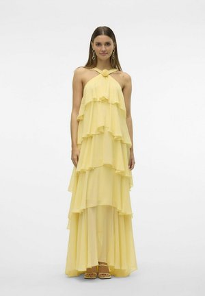 Layered yellow dress made of chiffon, featuring ruffled tiers, a halter neckline with floral accent, and a floor-length silhouette.
