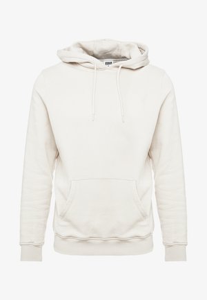 Kreemikas värvitooniga kapuutsiga sviitri, mis on valmistatud pehmest kangast. Sellel on suur esikott, reguleeritav kapuutsi nöör, soonikservad ja äär. Lihtne disain, ilma mustriteta.