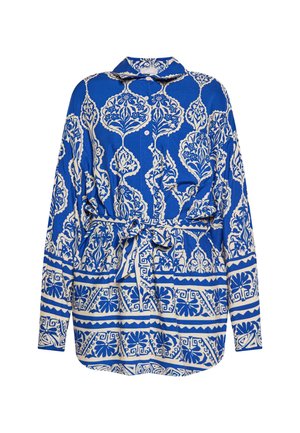 Kék mintás blúz, gallérral, fehér virágos és geometrikus mintákkal, hosszú ujjal és derékban megkötős övvel.